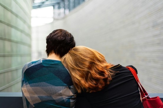 A woman resting her head on another person's shoulder